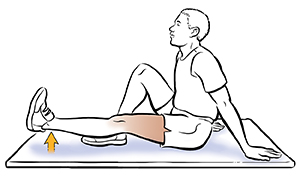 Man sitting on floor doing leg raise.