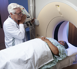 Healthcare provider preparing woman for CT scan.