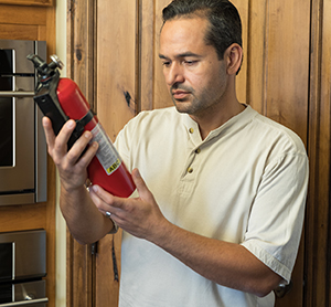 Man reading label on home fire extinguisher.
