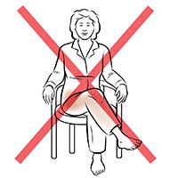 Front view of woman sitting in chair with legs crossed. Red X indicates not to do this.