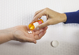 Close-up of a woman's hand putting pills in another woman's hand