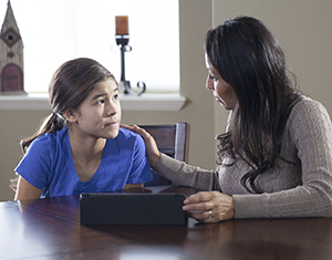Woman and teen girl looking at electronic tablet.