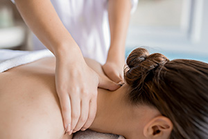 Therapist giving woman neck and shoulder massage.