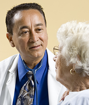 Healthcare provider talking to elderly woman.