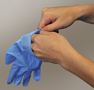 Hands putting on surgical gloves.