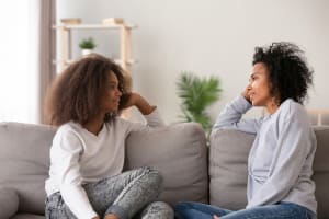 Teen daughter and mother spending quality time together on the couch.