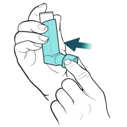 Hand holding inhaler upright, with other hand placing cap back on mouthpiece.