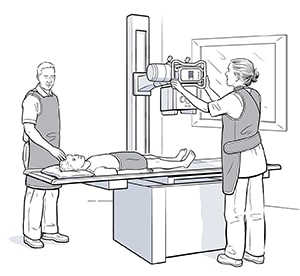 Child lying on back on table under X-ray machine to do X-ray of feet.