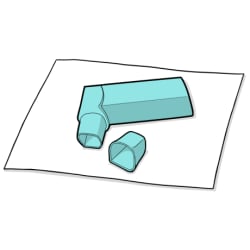 Tapa tumbada junto al inhalador sobre una toalla de papel.