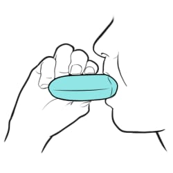 Side view of person holding inhaler to their mouth.
