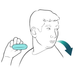 Person holding inhaler, with head turned aside, breathing out through pursed lips.